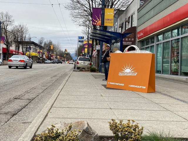 The artistic and massive shopping bag of Sunset on Fraser at 47th Ave in front of Vancity promoting the Shop Local Often campaign and all the information about our wonderful shopping district