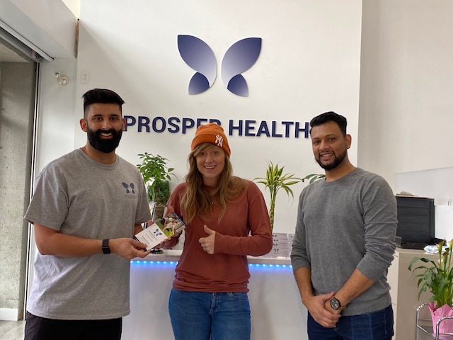 Carly Plett receives a certificate for a free one-hour massage at Prosper Health & Rehab from owner Dr. Kirtpaul Sandhu and staff.